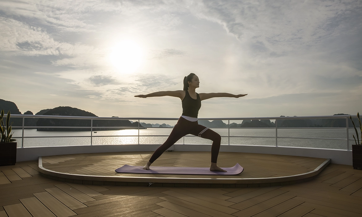 Guest practicing sunrise yoga aboard a luxury Ha Long Bay cruise